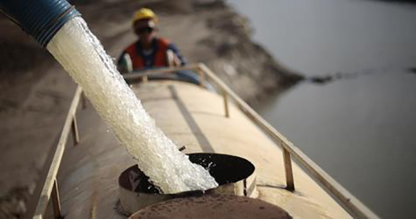A worker fills a truck with water pumped from one of the canals being built to divert water from the Sao Francisco river for use in four drought-plagued states, a project that is three years behind schedule and has doubled in cost from the original estimate of $3.4 billion, near the city of Mauriti, Ceara state, January 28, 2014. In 2006, then President Luiz Inacio Lula de Silva, pushed through an idea that long-suffering residents of the region had been hearing about for more than a century. By 2010, Lula de Silva said, water would be pumped over hills and into a 477 kilometer-long network of canals, aqueducts and reservoirs to quench thirsty cities and farms in four states. Eight years later, and near the end of a first term for Lula's hand-picked successor as president, Dilma Rousseff, the project is only half built. Picture taken January 28, 2014. To match Feature BRAZIL-DROUGHT/CANAL REUTERS/Ueslei Marcelino (BRAZIL - Tags: POLITICS ENVIRONMENT AGRICULTURE BUSINESS) - RTX18IBL