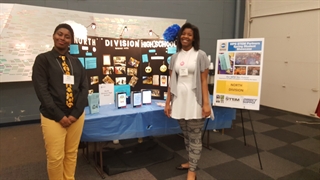 North Division students Qiaira Matthews (left) and Tatiana Loyd (right) showcase their mobile app -- which is now one of six winners in a national competition -- at the MPS STEM Partners Spring Student Showcase