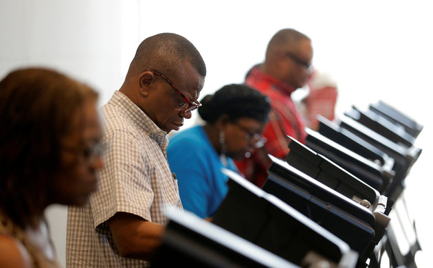 A voter casts his ballot during early voting at the Beatties Ford Library in Charlotte, North Carolina October 20, 2016. REUTERS/Chris Keane